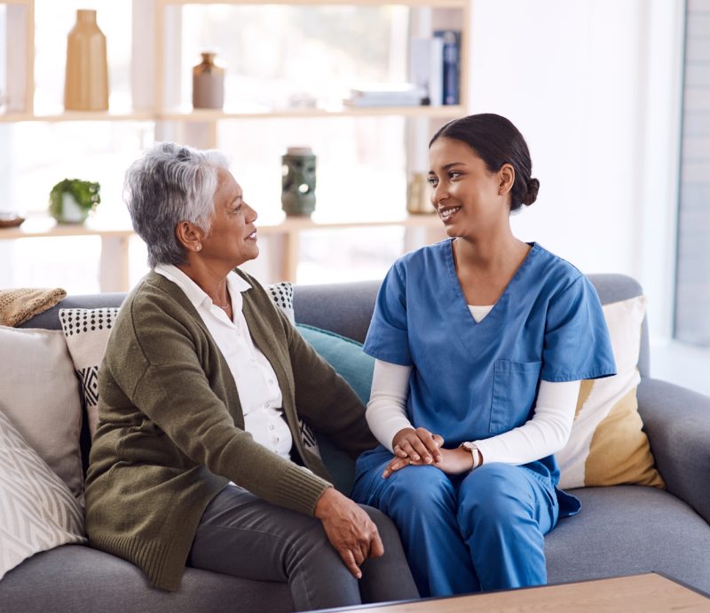 Shot of a young nurse chatting to a senior woman in a retirement home